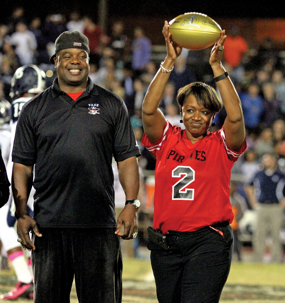 Former Page High & New York Giant running back Lee Rouson presents Page High School Principal, Patrice Faison, with a golden football during half time of the Page - Grimsley rivalry game. Photo by Joe Daniels / Carolina Peacemaker