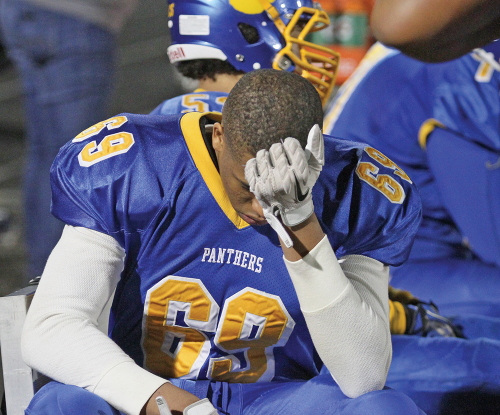 Dudley High School football player Brylyn Harris, a junior defensive lineman, sits and reflects on the Panthers 17-8 loss to Charlotte Catholic in the NCHSAA Class 4-A Regional. Photo by Joe Daniels